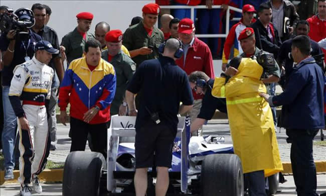 Pastor Maldonado (i), que observa cómo el presidente venezolano, Hugo Chávez (2i), analiza su vehículo